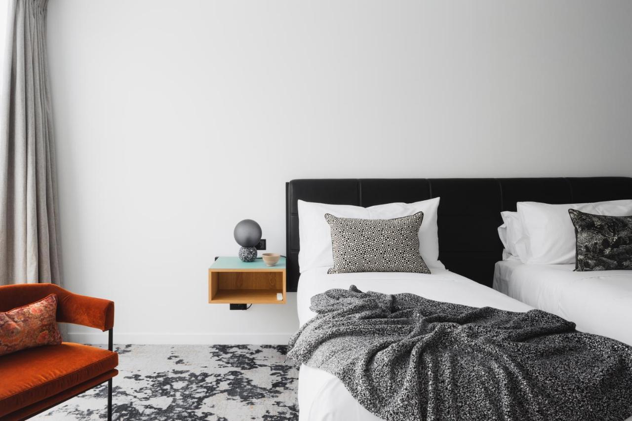 Ebb-Dunedin Exterior photo A bedroom with a bed, a chair and a nightstand