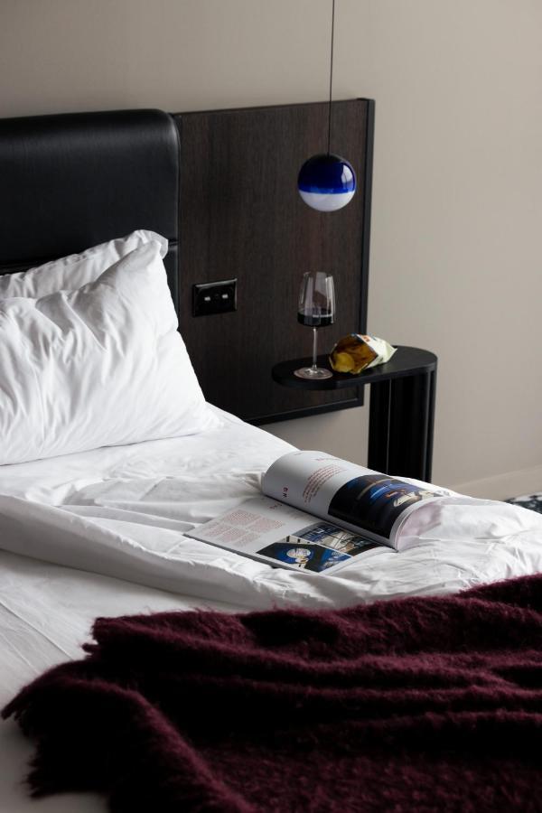 Ebb-Dunedin Exterior photo A bed with a magazine and a wine bottle